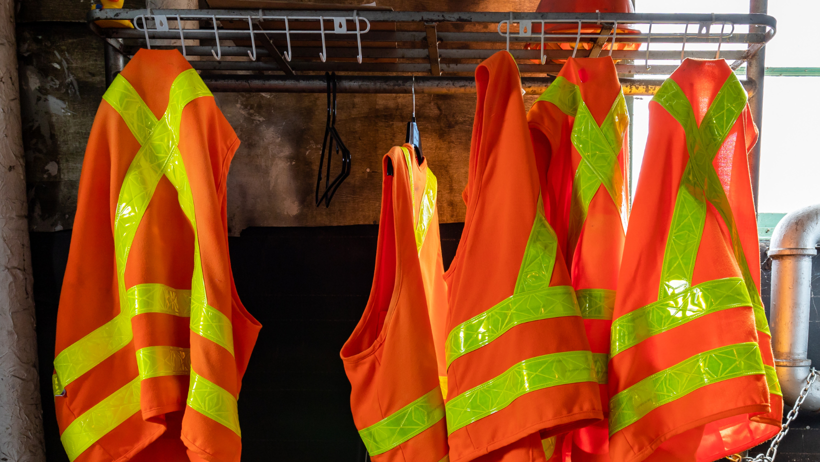 Orange safety vests hanging at a worksite.