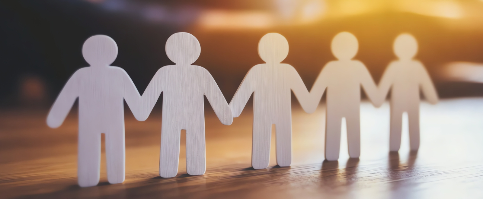 Hands holding paper people cutouts