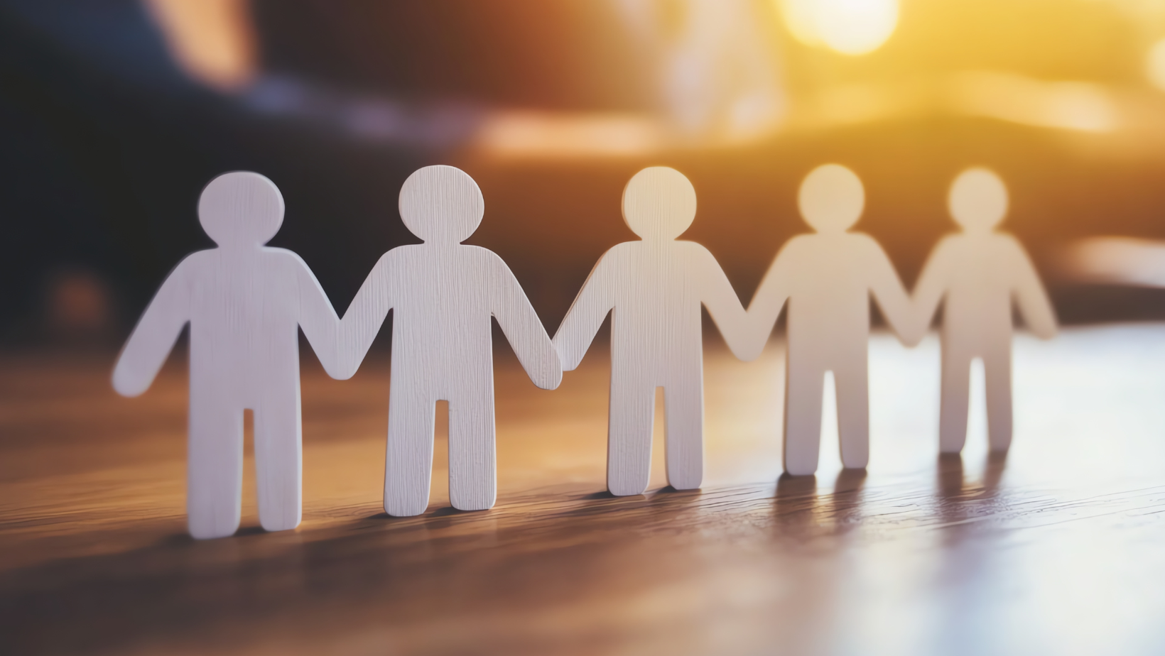 Hands holding paper people cutouts