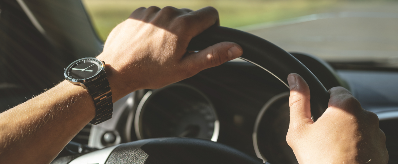 Hands on a steering wheel.