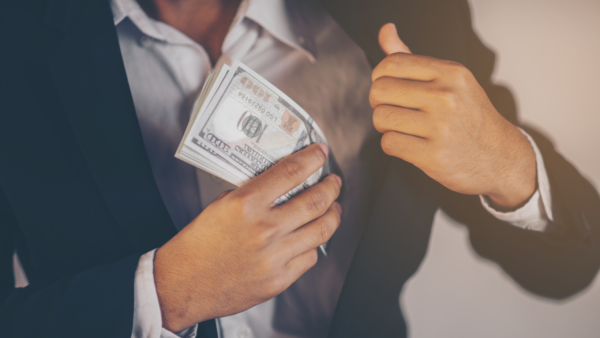 A man putting money in his jacket pocket.