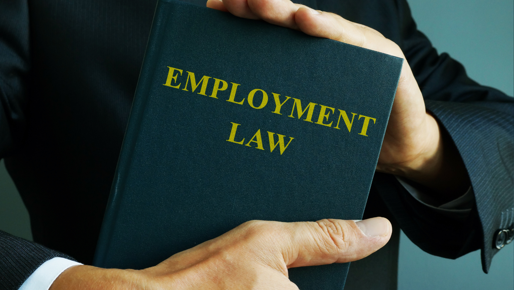 Man holding book titled, "Employment Law"